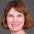 Maria Rodriguez, M.D., M.P.H. (OHSU) Maria has cropped brown hair, a hot pink sweater and is smiling against a gray/brown background.